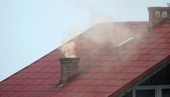 dach z kopcącym kominem - smog